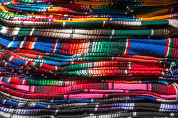 Fototapeta na wymiar Colorful Mexican serapes hang in row. 