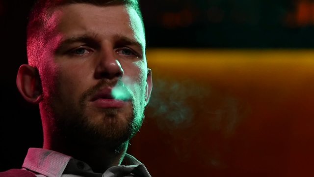man smoking shisha at restaurant. Slow motion. silhouette
