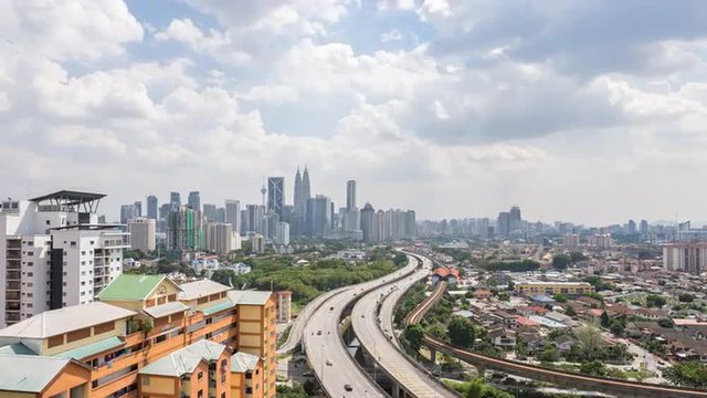 Time lapse HD footage of road lead to Kuala Lumpur city center. Showing moving cars and moving clouds during daylight.