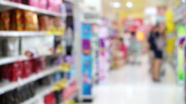 Asian girl, woman walking, looking and shopping snacks in blur supermarket isle