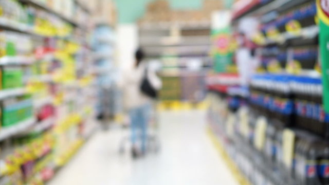 Asian girl, woman walking, looking and shopping snacks in blur supermarket isle