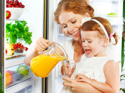 "happy family mother and baby daughter drinking orange ...