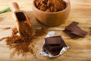 Chocolate bars with a bowl of cacao powder.