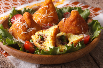 arancini with meat and peas close-up on a plate. Horizontal
