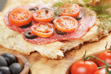 sandwich with pita bread salami and vegetables on wood table