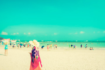 Blurred people on white sand beach with blue sea an sky background, vintage tone