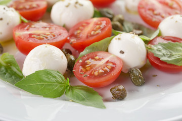 caprese salad with mini mozzarella balls, tomatoes and capers