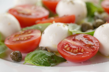 caprese salad with mini mozzarella balls, tomatoes and capers