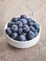 fresh blueberries in bowl on wood table