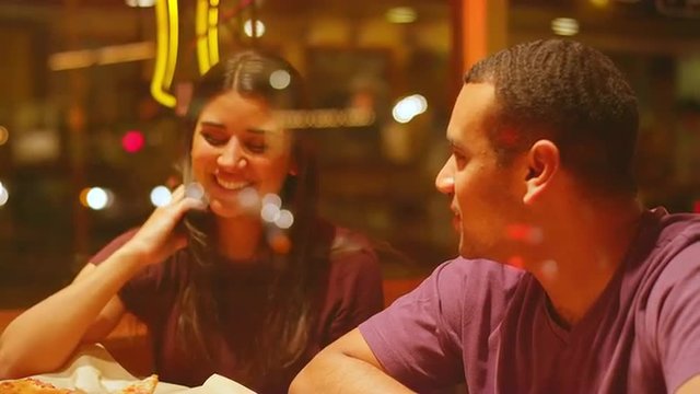 A Young Couple Eating At A Downtown Pizzeria