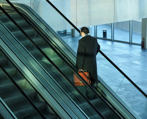 Businessman going up an escalator