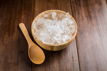 wooden Bowl with ice Cubes on wooden background