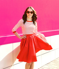 Pretty sweet woman in red sunglasses and flying skirt against th
