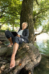 Businessfrau sitzt mit Tablet am Wasser und macht eine Pause