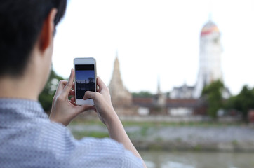 Tourist in Thailand taking pictures of Thai temple by Cell phone