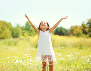 Naklejka na ściany i meble Happy little girl child enjoying sunny summer day and having fun