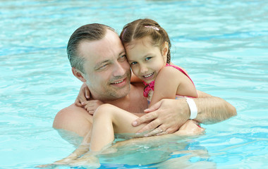 Dad and daughter relax in  pool