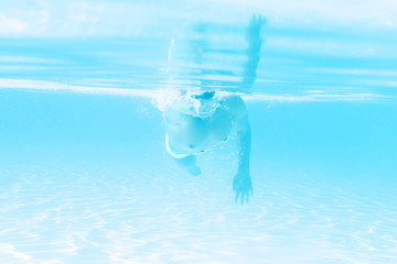 young man swimming the front crawl style in a pool