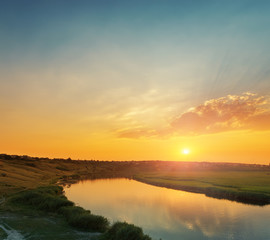 orange sunset with clouds over river