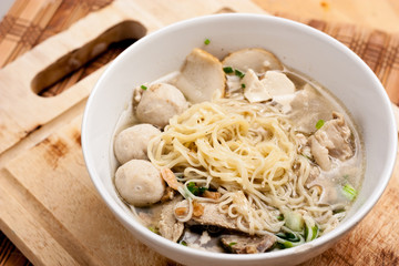 Rice Noodles Bone Soup with Meat Balls and Fish Balls on wood background,Thai food.