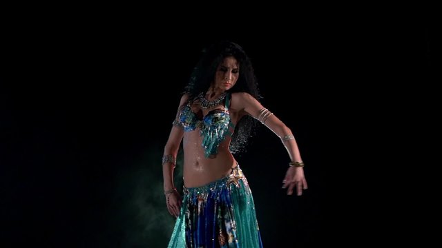 Beautiful young belly dancer in blue exotic costume go on