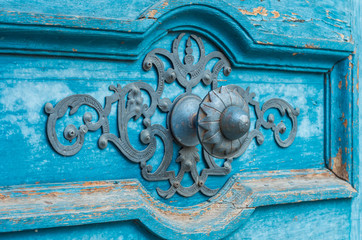 Blue wooden door with ornamented iron handle