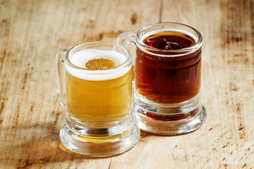 Light and dark beer in old-fashioned circles on old wooden table