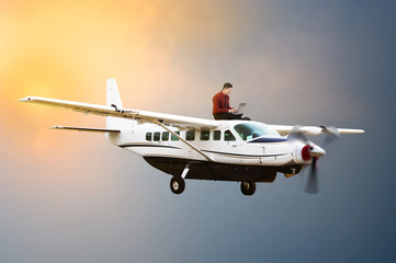 Young business man sit on the top of airplane