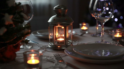 Christmas theme. Festive table setting with candles, gifts and Christmas lantern