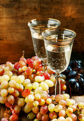Champagne in glasses and fresh grapes, still life, selective foc