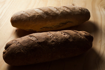 Due pagnotte di pane fatte a mano su un tagliere di legno . 