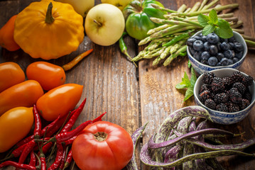 Colorful fresh vegetables of all colors on the wooden background