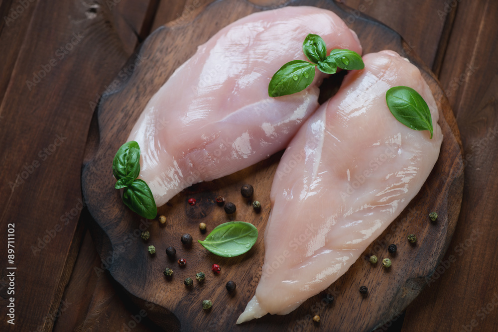 Poster Cutting board with raw chicken breast fillet, top view, close-up