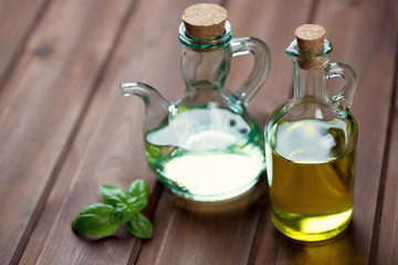 Olive oil in glass bottles and fresh green basil, studio shot