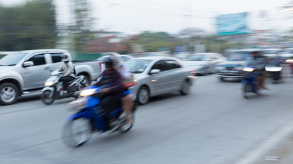 Fototapeta na wymiar car and motorcycle driving on road with traffic jam in the city, abstract blurred