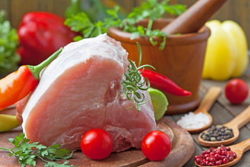 Raw pork steak - ready for cooking with herbs