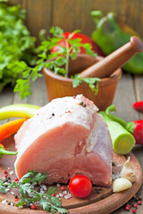 Raw pork on cutting board and vegetables 