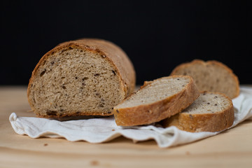 Pagnotta di pane integrale fatto a mano su un tavolo di legno. Sfondo nero