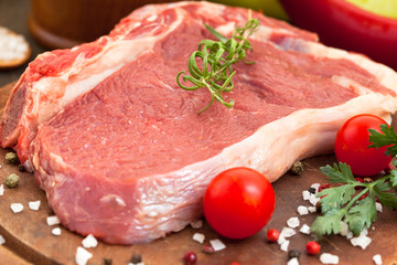 Raw beef steak on a dark wooden table