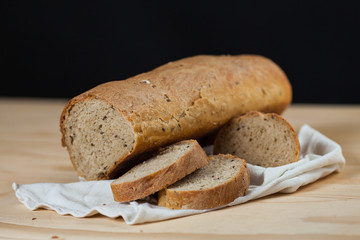 Pagnotta di pane fatto in casa tagliato a fette su un tavolo di legno