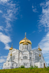 Fototapeta na wymiar Belogorsky Cathedral. Russian Orthodox Church with golden domes under blue skies.