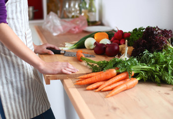Young woman cutting vegetables in the kitchen