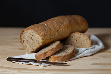 Pagnotta di pane integrale fatto a mano su un tavolo di legno. Sfondo nero
