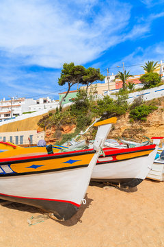 Fototapeta Traditional colourful fishing boats on beach in Carvoeiro village, Algarve region, Portugal
