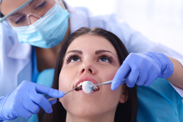 Woman dentist working at her patients teeth