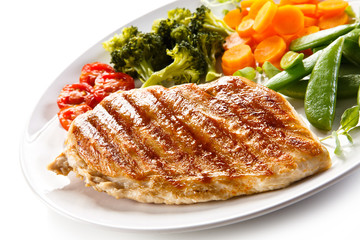 Roast chicken fillet and vegetables on white background 