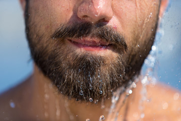 Mann mit Bart unter der Dusche