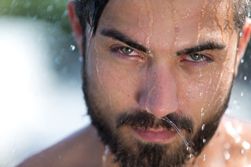 Mann mit Bart unter der Dusche