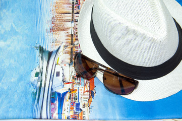 Summer background with glasses and hat on the blue fabric texture