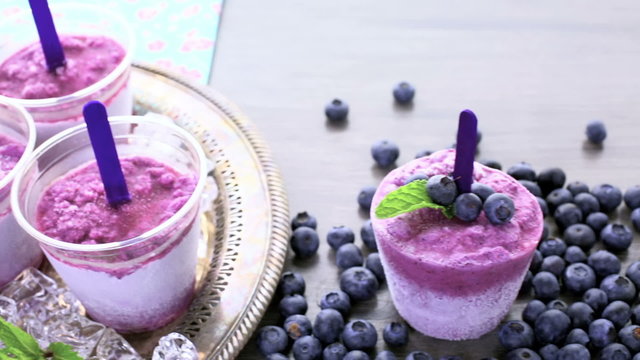 Homemade blueberry popsicles made in plastic cups